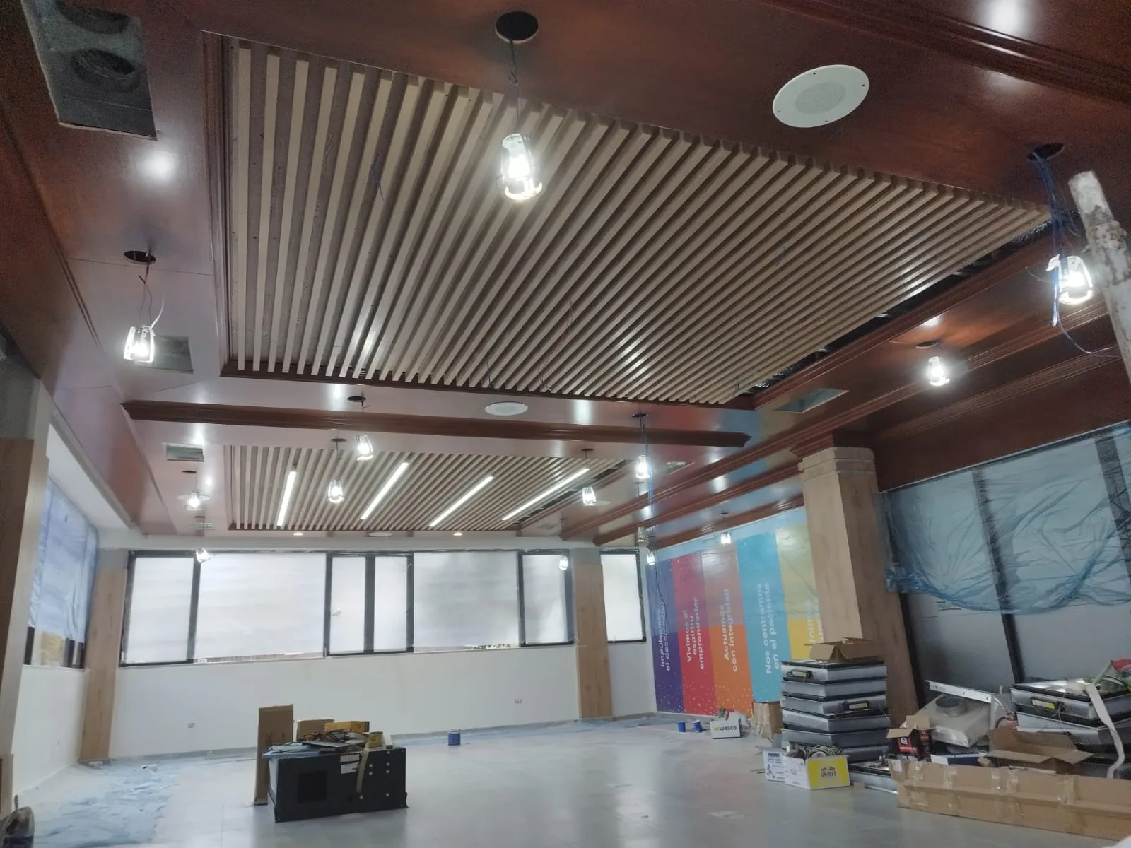 Cielo raso de listones de madera en proceso de instalación en sala de reuniones